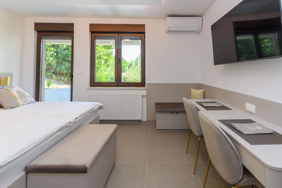 A bedroom with a bed, a desk, and a chair.
