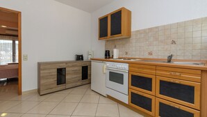 A kitchen with a built-in oven, a coffee maker, and a sink. - Apartments Maky (Rab)