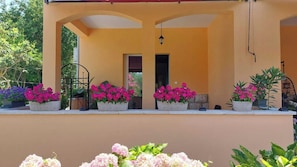 Ein Gebäude mit Balkon, Blumentöpfen und einer Tür.