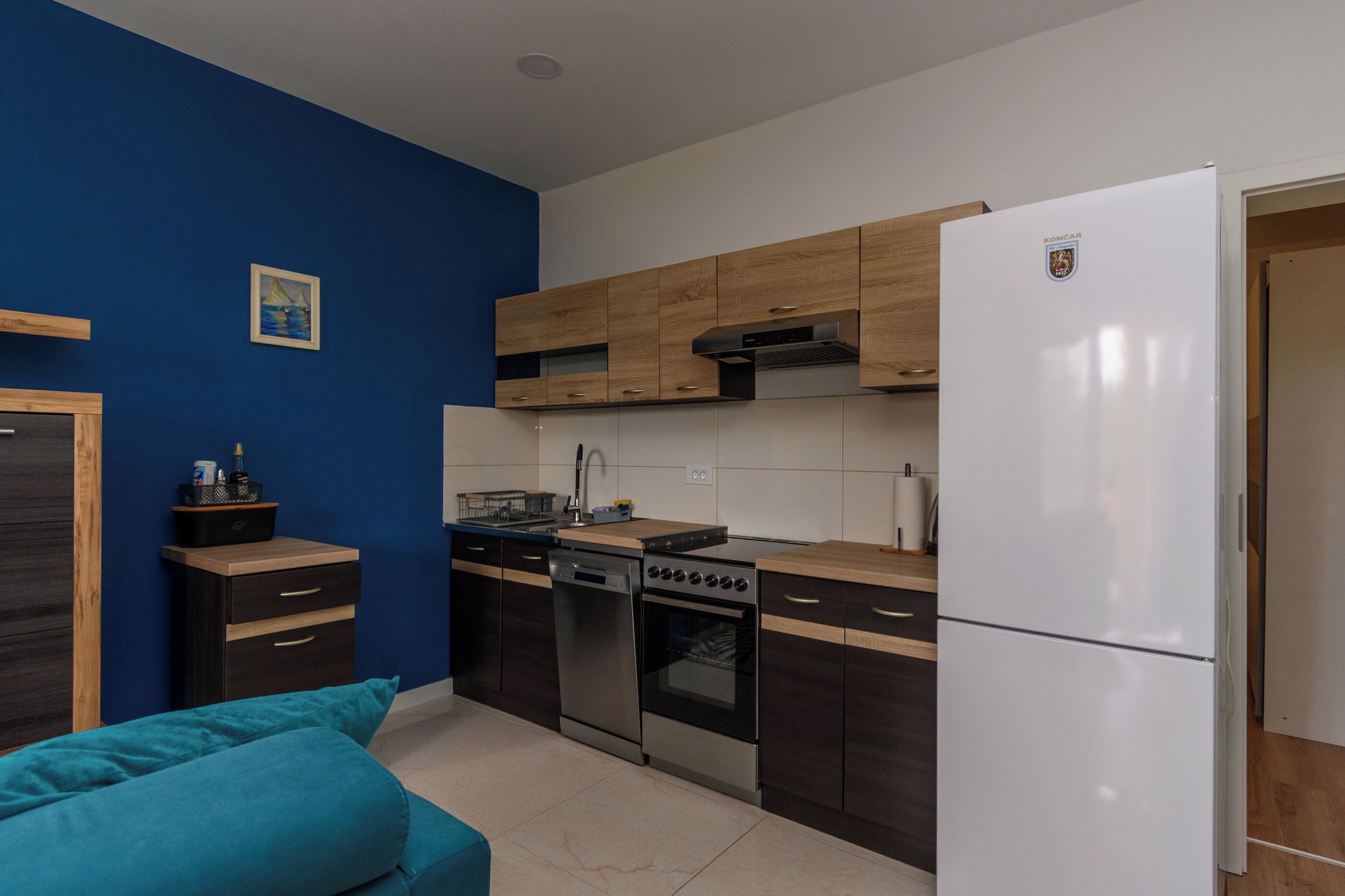 A modern kitchen with wooden cabinets, a stainless steel stove, and a white refrigerator.