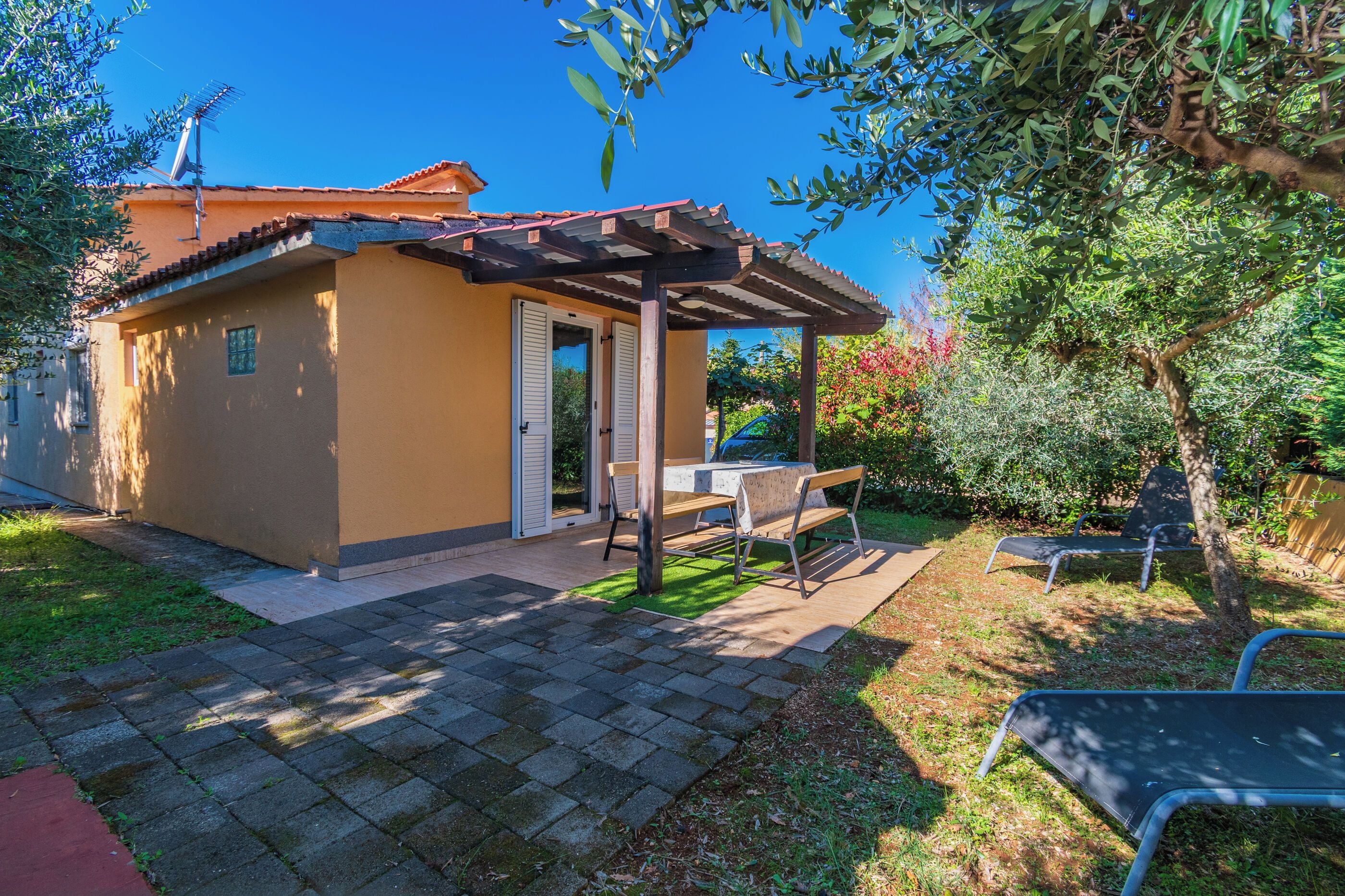 A small house with a patio, a table, and chairs.