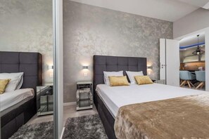 Un dormitorio moderno con una cama grande, mesitas de noche y un espejo.