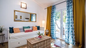 A room with a bed, a wooden coffee table, a mirror, and a window with curtains. - Apartments Tellus (Biograd na Moru)