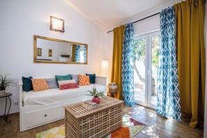 A room with a bed, a wooden coffee table, a mirror, and a window with curtains. - Apartments Tellus (Biograd na Moru)