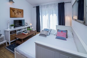 A bedroom with a bed, a TV, a desk, and a window with curtains. - Apartments Tellus (Biograd na Moru)