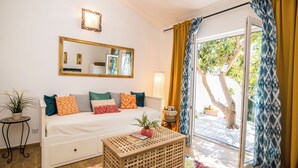 A room with a bed, a small table, a mirror, and a view of the outdoors. - Apartments Tellus (Biograd na Moru)