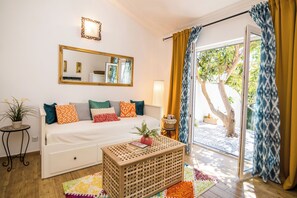 A room with a bed, a small table, a mirror, and a view of the outdoors. - Apartments Tellus (Biograd na Moru)