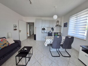 A modern apartment with a living room, dining area, and kitchen. - Apartment Roko (Crikvenica)