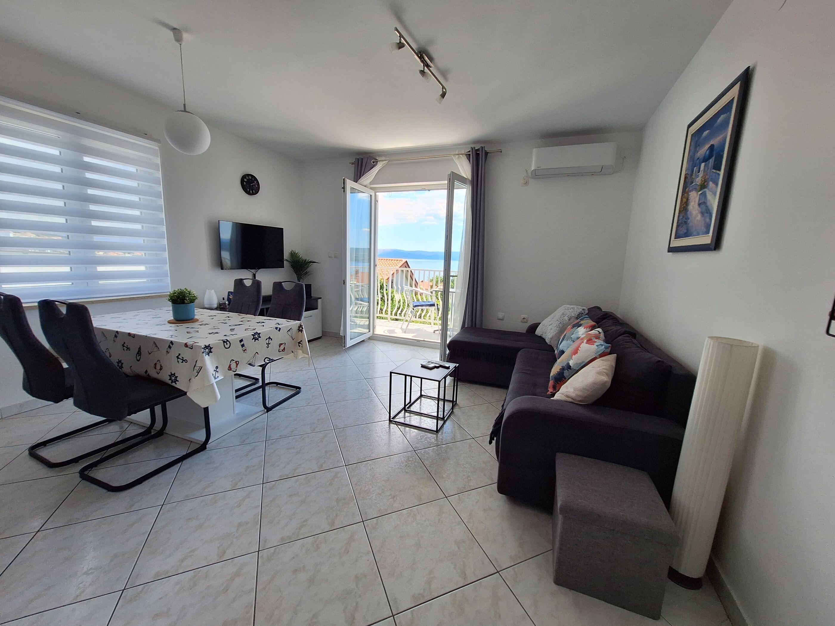 Un salon moderne comprenant un coin repas, un canapé, un téléviseur et un balcon avec vue.