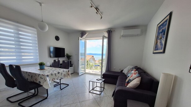 Un salon moderne comprenant un coin repas, un canapé, un téléviseur et un balcon avec vue.