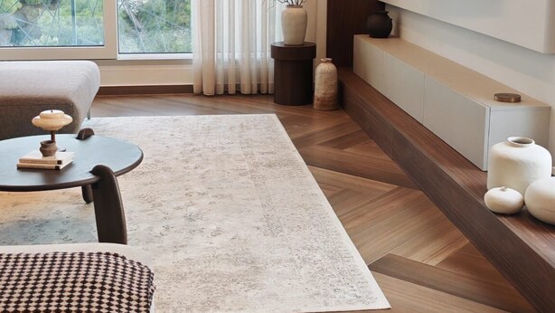 Un salon moderne avec un canapé, une table basse et un téléviseur fixé au mur.