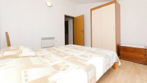Una camera da letto con un letto, un armadio e una cassettiera.