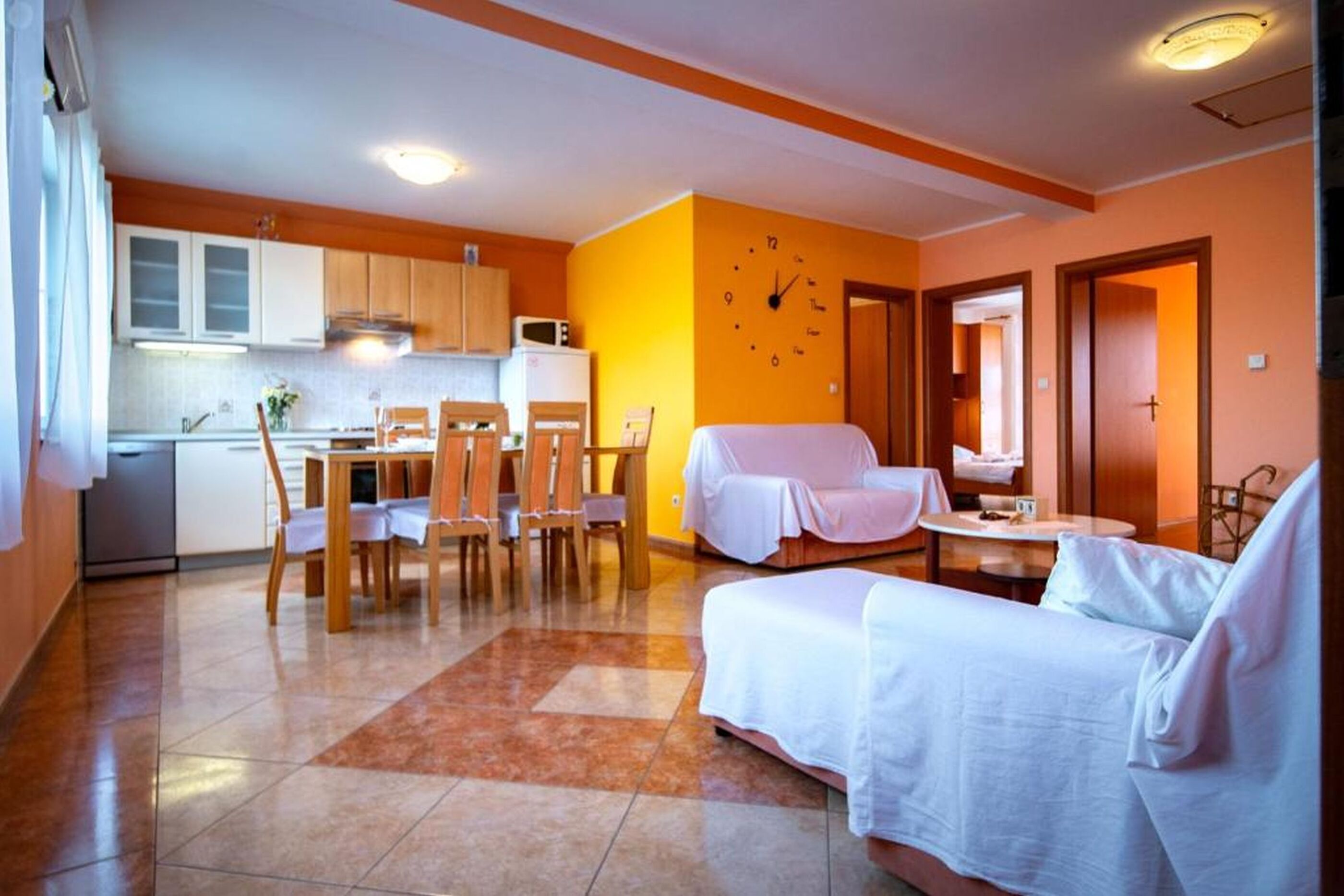 A compact living space with a dining area, kitchenette, and a bed.