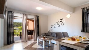 Una sala de estar moderna con un sofá, una mesa de centro y una mesa de comedor preparada para el desayuno.