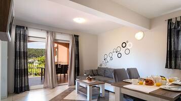 Una sala de estar moderna con un sofá, una mesa de centro y una mesa de comedor preparada para el desayuno.