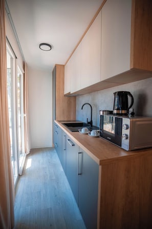 Una cocina moderna con estufa integrada, cafetera y lavaplatos.