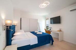 A modern hotel room with a bed, desk, and TV. - Apartment Tatjana (Split)