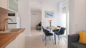 Eine moderne Küche mit Spüle und einem Essbereich mit Stühlen und einem Tisch.