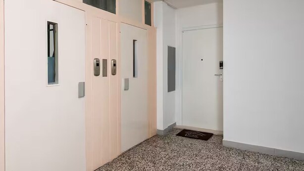 Ein Flur mit einer Tür, einem Klingel und einem Briefschlitz.