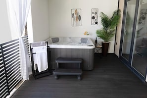 A hot tub on a wooden deck with a towel rack and a potted plant. - Mobile Home Maris With Jacuzzi (Vodice)