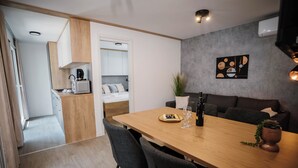 Eine moderne Küche mit Mikrowelle, Kaffeemaschine und einem Essbereich mit Holztisch und Stühlen.