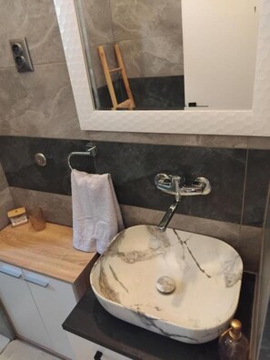 A bathroom with a marble sink, a towel, and a mirror. - Apartment Buska (Vir)