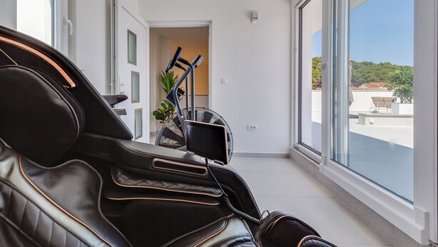 Een moderne kamer met een groot raam, een plafondventilator en uitzicht op een balkon.