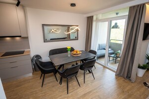Un comedor moderno con una mesa, sillas, un espejo y vistas al exterior.