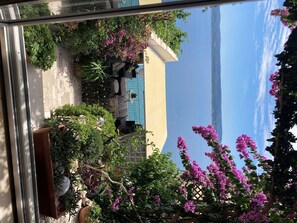 A poolside area with outdoor seating and lush greenery. - Apartment Sealine One (Omis)