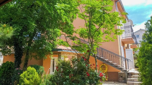 A building with a staircase, a garden with various plants, and a clear sky. - Apartments Eden (Crikvenica)