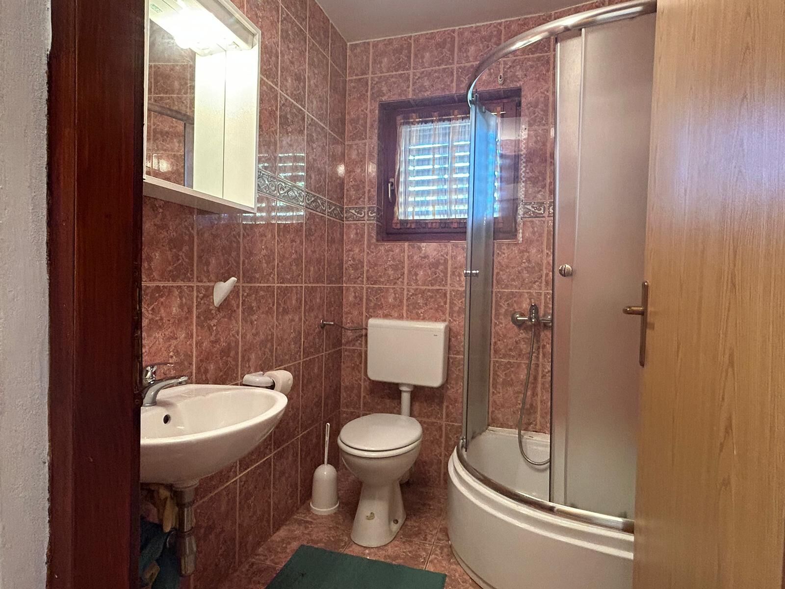 A bathroom with a sink, toilet, and shower.