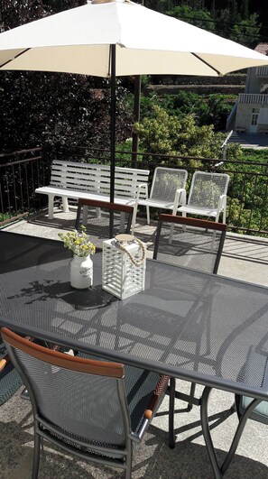 An outdoor seating area with a table, chairs, and an umbrella. - Apartment Ana-marija (Jelsa)