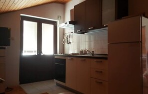 Eine Küche mit Kühlschrank, Herd und Schränken.