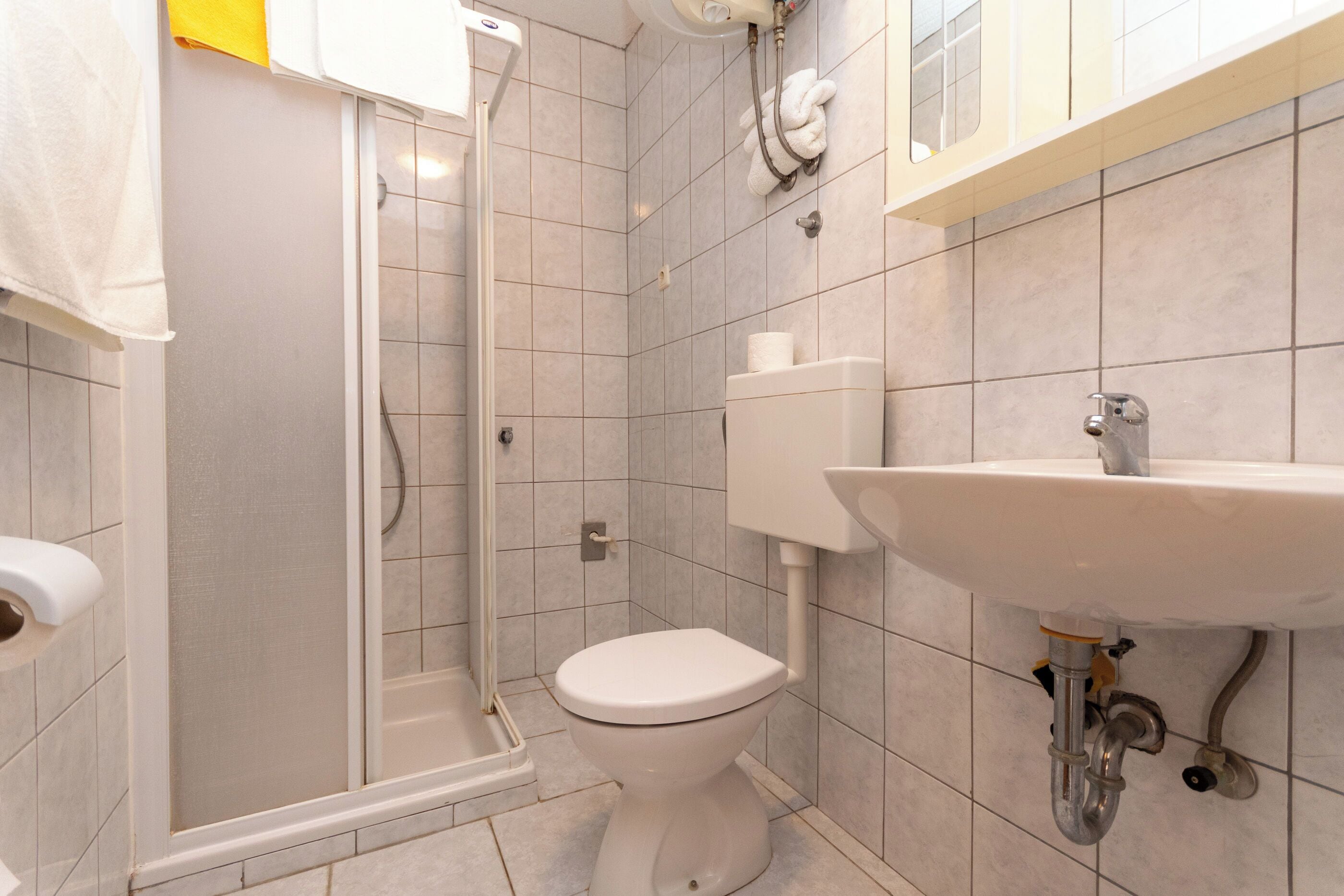 A bathroom with a shower, toilet, and sink.