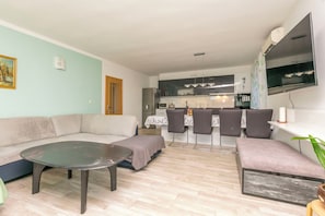 Ein Wohnzimmer mit einer Couch, einem Couchtisch und einem Essbereich mit Stühlen und Tisch.