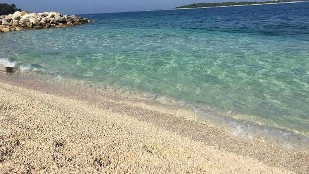 A clear beach with pebbles and calm water. - Apartment Niko (Pula)