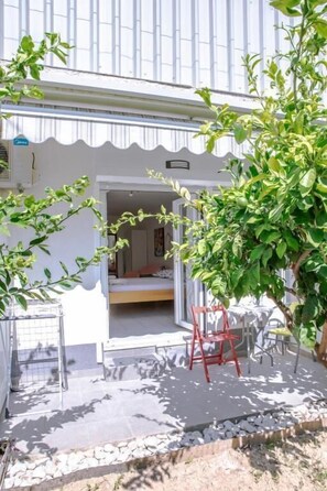 A room with a bed, a small table, and a chair. There is a window with a view of the outside. - Apartments Studio Spalato (Split)