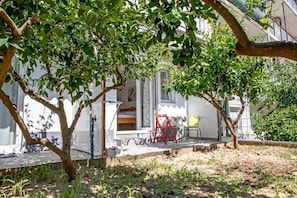 A residential property with a covered porch, a red chair, and a small table. - Apartments Studio Spalato (Split)