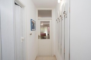 A narrow hallway with white walls, a door at the end, and a framed picture on the left. - Apartments Studio Spalato (Split)
