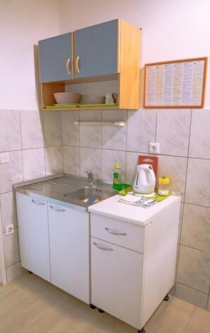 A compact kitchen with a sink, cabinets, and a small countertop. - Apartments Studio Spalato (Split)