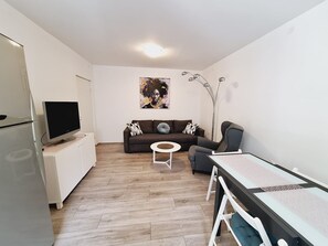 A compact living space with a kitchenette, a sofa, a dining table, and a TV. - Apartment Sia (Crikvenica)