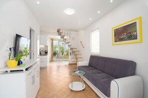 A modern living room with a sofa, a TV, a dining area, and a staircase. - House Lila Jacuzzy (Trogir)