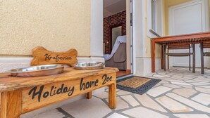 A wooden bench labeled 'Holiday home 2oe' with a metal bowl and a bone-shaped object. - House Holiday Home Zoe (Kraljevica)