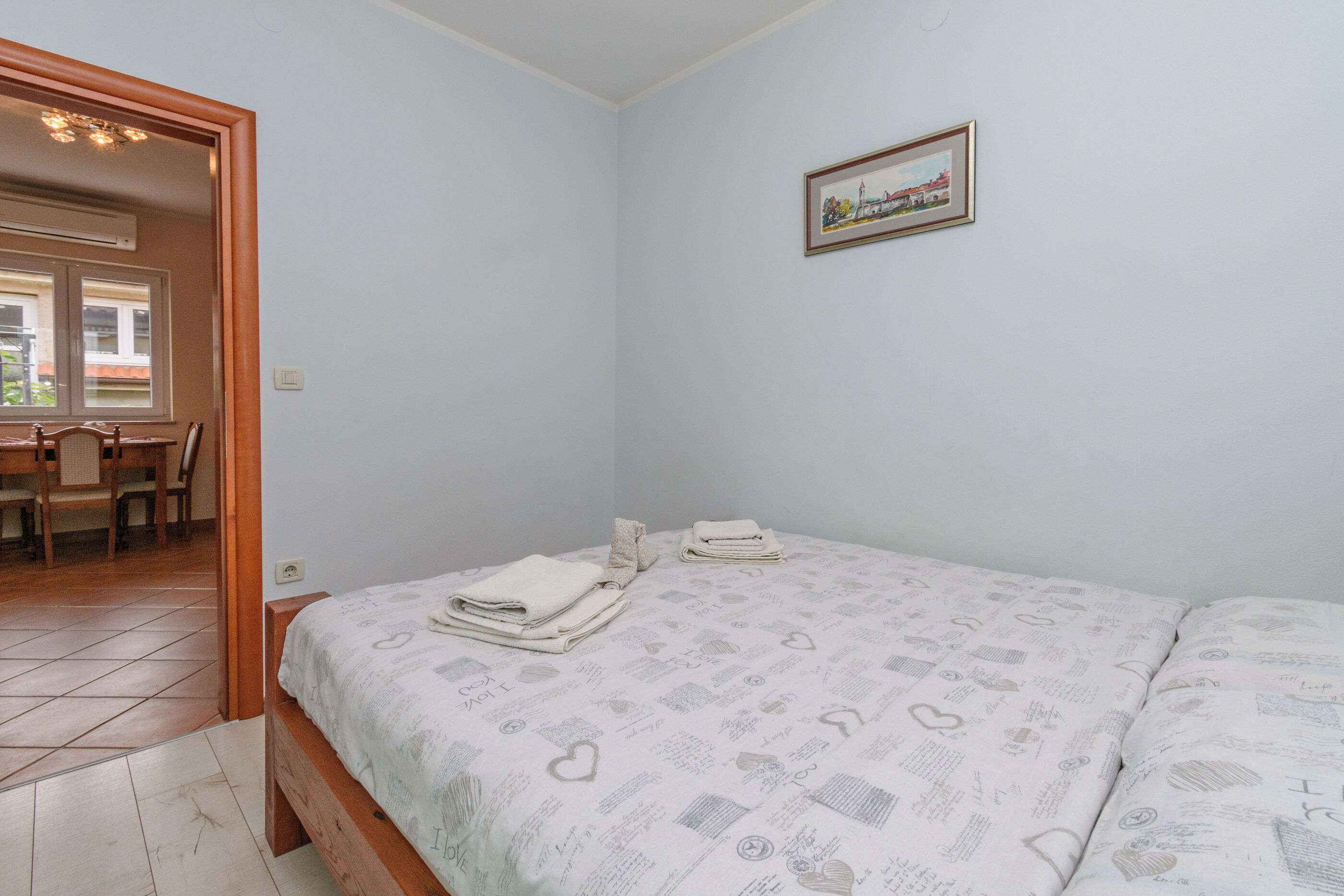 Une chambre à coucher avec un lit, une chaise, un bureau et un tableau au mur.