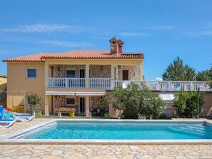 A two-story building with a swimming pool, a balcony with a white railing, and a stone facade. - House House Lola (Rasa)