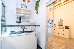 Eine moderne Küche mit Spüle, Kochgeschirr und einer Uhr an der Wand.