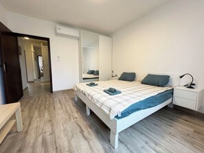 Ein Schlafzimmer mit Bett, Nachttisch und Kleiderschrank.
