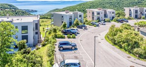 Un área residencial moderna con edificios de varios pisos, un estacionamiento y vista a un cuerpo de agua.