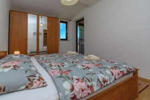 A bedroom with a bed, a wardrobe, a mirror, and a window. - Apartment Nikola (Porec)