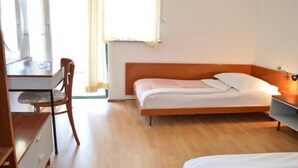 A bedroom with a bed, a desk, and a chair. - Apartments Oliva (Sibenik)